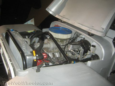 1990 Ford Bronco - Open engine bay of a silver vehicle showing a chrome round air filter, MSD ignition box and polished aluminum radiator with braided lines.