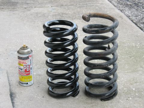 1997 Ford Crown Victoria - A can of PB penetrating oil sits beside two coil springs, one new and one old.