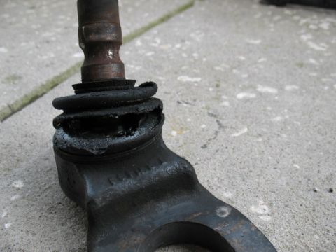 1997 Ford Crown Victoria - Close-up of a damaged ball joint, showing a torn rubber boot and expelled grease.