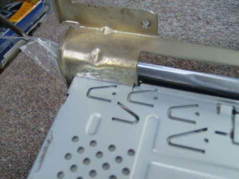 1979 Ford F-100 - Close-up of a car radio mounting bracket, showing its metal construction and securing tabs.