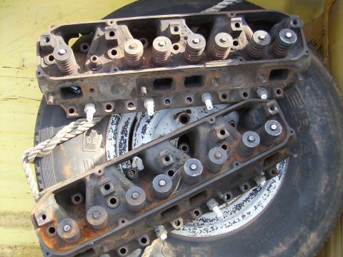 1979 Ford F-100 - A pair of engine cylinder heads, likely from a Ford truck, are shown resting on a tire. The registry claims they are from a 1979 Ford F-100.