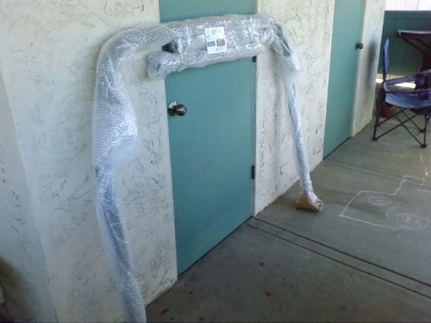 1995 Ford Bronco - A car part, possibly a bumper or roll bar, is covered in bubble wrap and leaning against a wall.