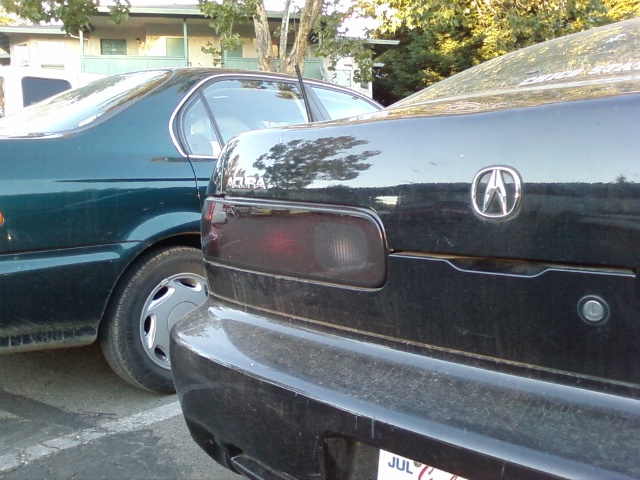 Black Acura Integra rear, left taillight visible, Acura logo on trunk
