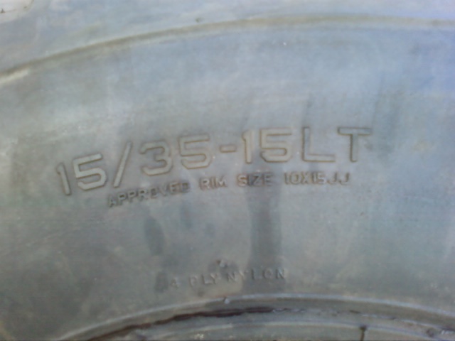 Close-up of tire sidewall showing size 15/35-15LT and approved rim size 10x15JJ