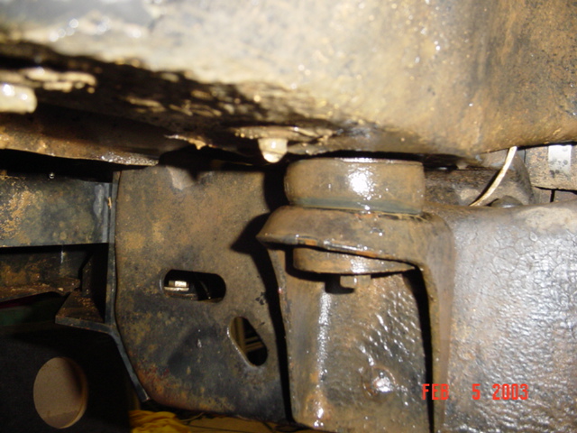 Underside view of rusty frame rail and body mount bushing on a 1985 Ford Bronco, dated Feb 5 2003