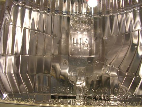 2007 Mazda 3 - Close-up of a headlight assembly showing H4 bulb type and E4 certification, manufactured in Germany.