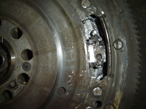 1992 Ford Bronco - This flywheel has sustained significant damage, with a large piece broken off and the surrounding metal showing wear.