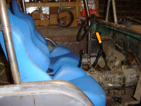 1992 Ford Bronco - The interior of a vehicle is shown, bright blue racing seats and a visible manual transmission shifter.