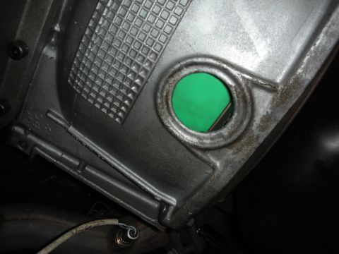 1992 Ford Crown Victoria - A close-up view of a vehicle's transmission housing, showing a circular opening and some attached wiring.