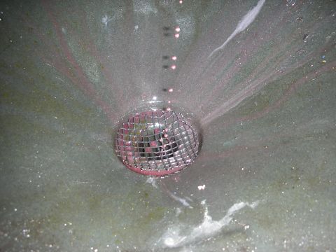 1992 Ford Crown Victoria - A close-up view of a drain with a metallic cover, set against a textured, speckled background.