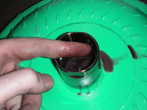 1992 Ford Crown Victoria - A finger is used to check the fluid level inside a green torque converter.