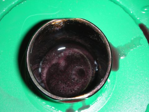 1992 Ford Crown Victoria - This is a close-up view of used transmission fluid collected in a metal container.