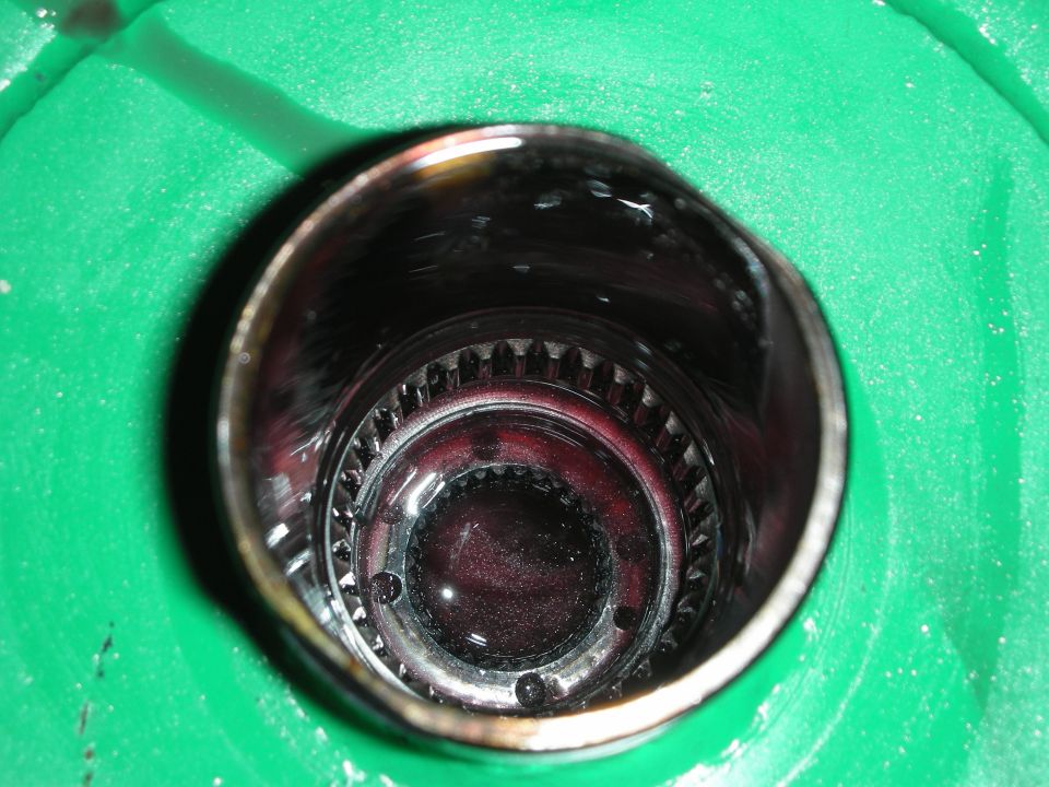 Close-up of a transmission part with internal gears and dark fluid