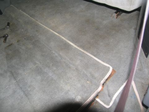 1995 Ford C-350 (Centurion Conversions) - Close-up of vehicle interior carpet, revealing a metal trim piece and two socket wrenches on the floor.