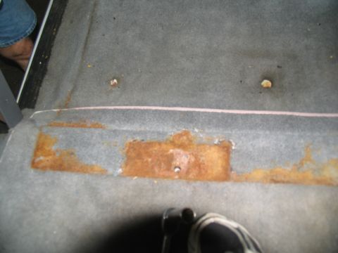1995 Ford C-350 (Centurion Conversions) - Car interior floor shows signs of rust and wear.