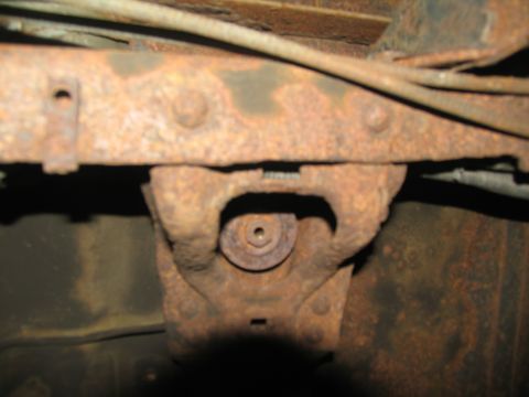 1995 Ford C-350 (Centurion Conversions) - Close-up view of a heavily rusted chassis component, likely part of the suspension or frame.