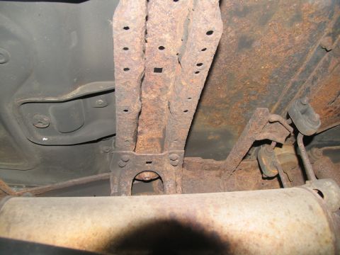 1995 Ford C-350 (Centurion Conversions) - Heavily rusted frame and exhaust components are visible on the underside of a vehicle.