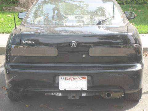 1995 Ford Bronco - The rear of a black Acura Integra is shown, tinted taillights and a California license plate.