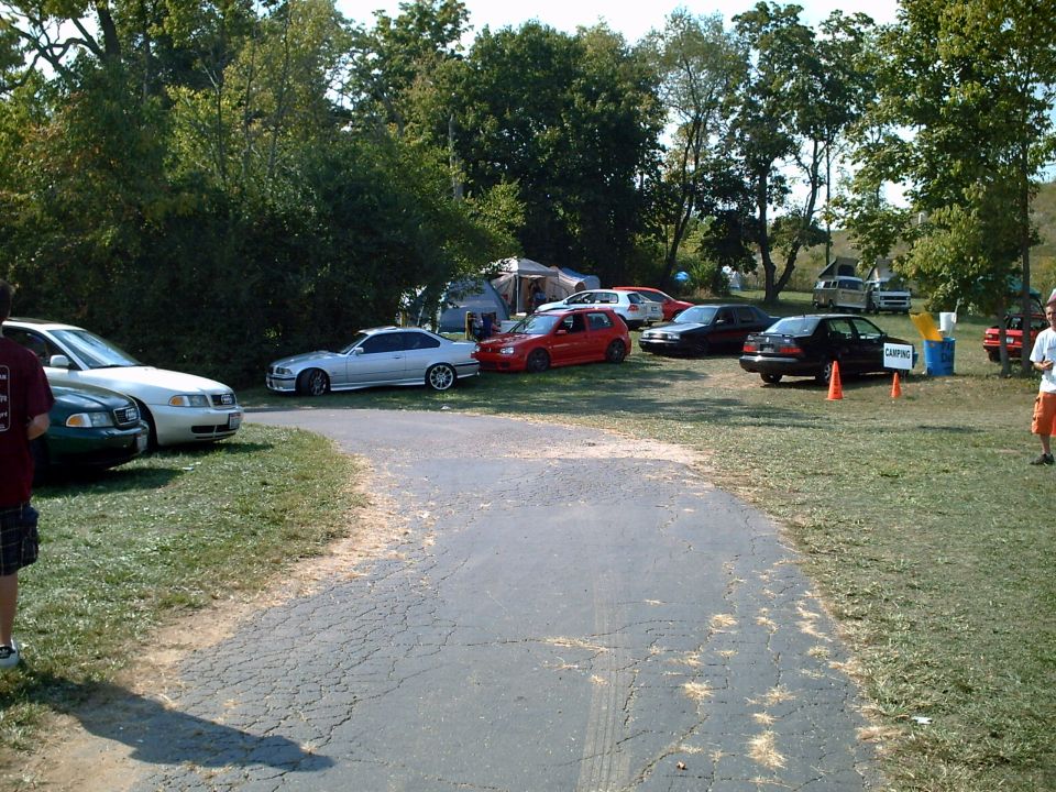 Silver coupe parked on grass, side view