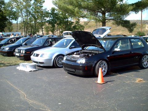 2003 Volvo S40 - A black Volkswagen Golf GTI is shown with its hood open, parked alongside other vehicles at an outdoor event.