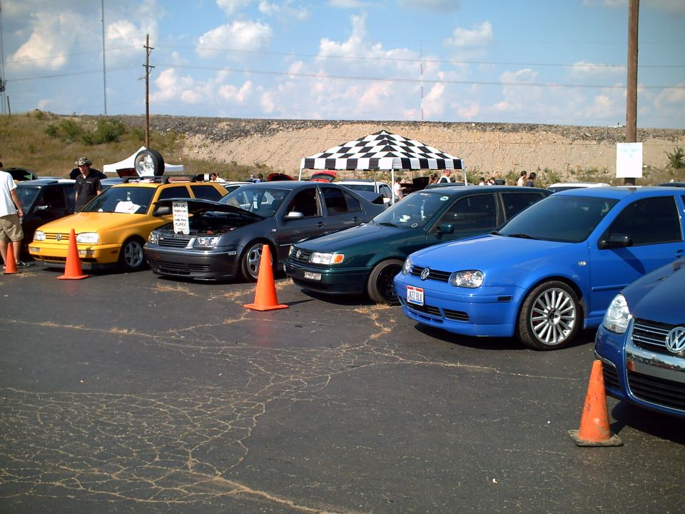 Volkswagen Golf and Jetta cars parked at a car show with checkered tent