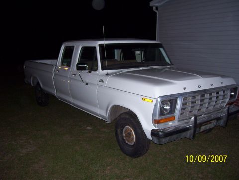 1978 Ford Bronco - White 1979 Ford F-350 crew cab pickup truck parked outside a building at night.