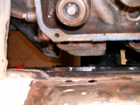 1978 Ford Mustang II - A close-up view of an engine block and the vehicle's undercarriage, showing some rust.