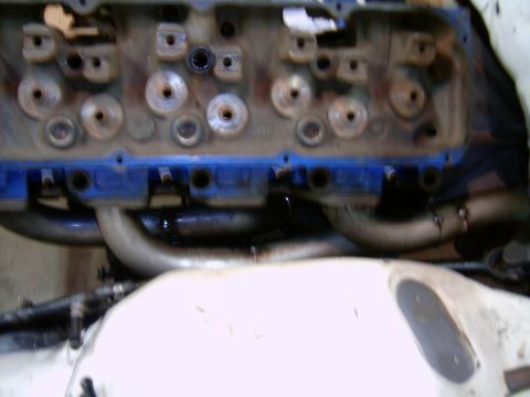 1978 Ford Mustang II - Close-up view of an engine block blue valve covers and custom exhaust headers, likely a performance modification.