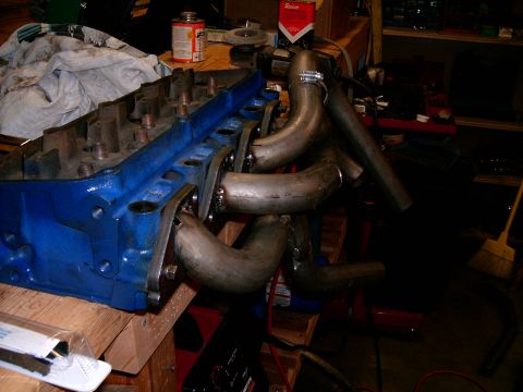 1978 Ford Mustang II - Custom exhaust headers are bolted to a blue engine block, likely for a performance upgrade.