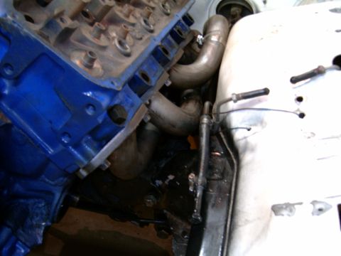 1978 Ford Mustang II - Custom exhaust headers are installed on a blue engine block, showing a portion of the engine bay.