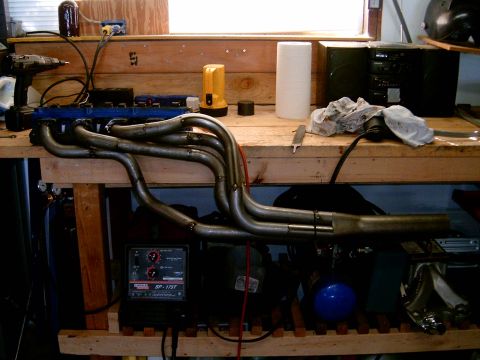 1978 Ford Mustang II - Custom exhaust headers are displayed on a workbench alongside a Lincoln SP-175T welder and various tools.
