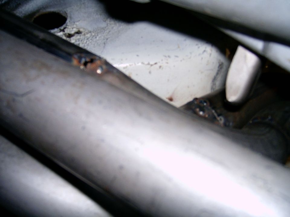 Close-up of welds on an exhaust pipe, showing some rust and discoloration