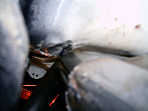 1978 Ford Mustang II - A close-up view of exhaust pipes and the underside of a vehicle, with visible welding marks.
