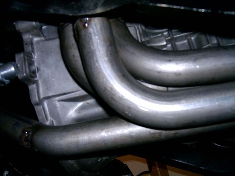 1978 Ford Mustang II - Close-up view of custom exhaust headers connected to a vehicle's engine block.