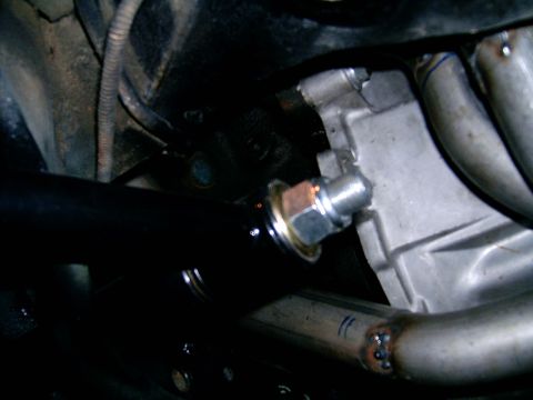 1978 Ford Mustang II - Close-up view of engine block and exhaust headers, with a black pipe visible in the foreground.