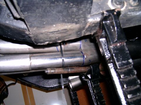 1978 Ford Mustang II - Exhaust pipes under a vehicle, held up by a jack stand during maintenance.