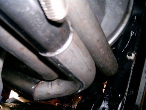 1978 Ford Mustang II - Close-up view of custom exhaust piping, showing welded joints and a section of flexible metal conduit.