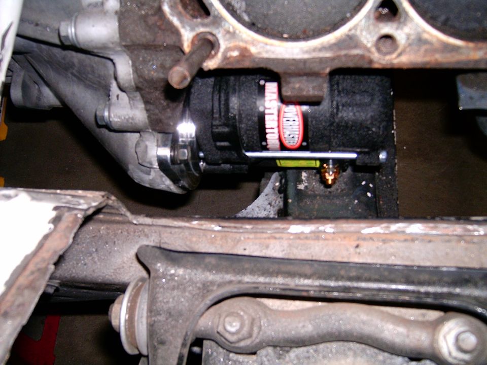 Close-up of an alternator with 'MASTER STATION' text, mounted to an engine block