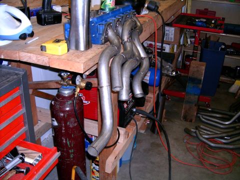 1978 Ford Mustang II - Custom exhaust headers are being fabricated with welding equipment in a workshop setting.