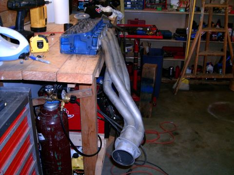 1978 Ford Mustang II - Engine components and workshop tools are laid out on a wooden workbench.
