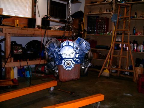 1978 Ford Mustang II - Engine block and headers hanging in a garage, ready for installation or rebuild.