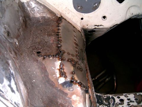 1978 Ford Mustang II - This image shows a section of an engine bay undergoing metal repair, with visible patches and numerous welds.
