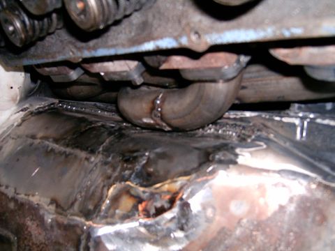1978 Ford Mustang II - Close-up view of engine components and exhaust pipe with a welded floor pan.