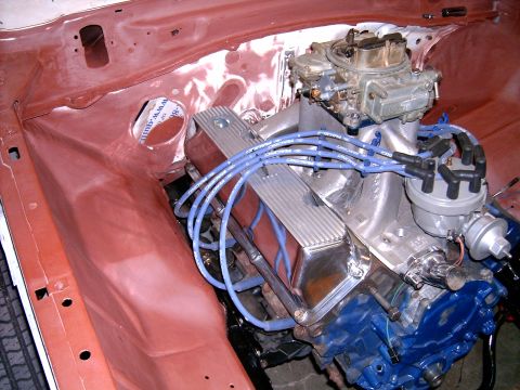 1978 Ford Mustang II - Close-up of a V8 engine in a car's engine bay, chrome valve covers and blue spark plug wires.