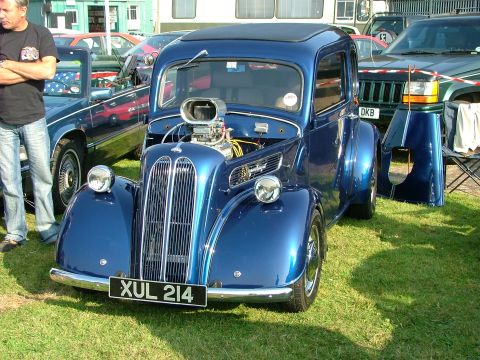 1988 Ford Sport - Customized blue hot rod with a prominent engine and unique grille, parked outdoors with other vehicles.