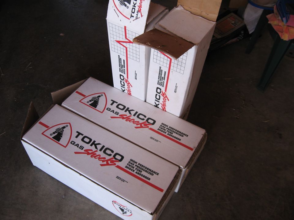 Boxes of Tokico gas shocks, two in the foreground, one open in the background