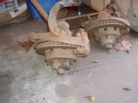 1991 Ford Bronco - These are two heavily rusted front axle assemblies, likely removed from a vehicle for repair or replacement.