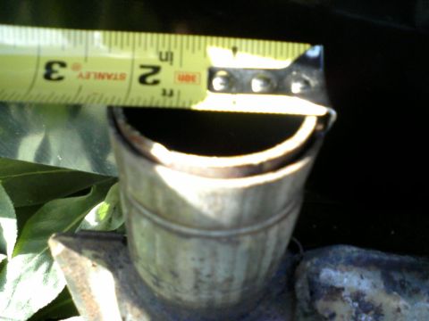 1996 Mercury Grand Marquis - A close-up shows an exhaust pipe being measured with a tape measure, indicating a diameter of about 2.5 inches.