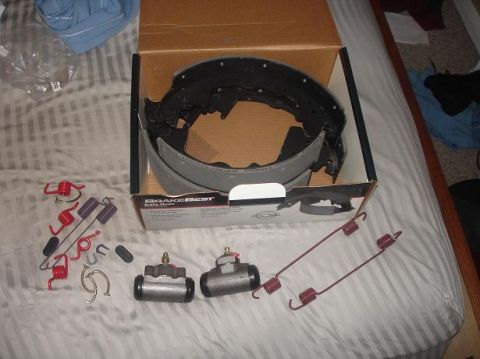 1996 Ford F-150 - New BrakeBest brake shoes, wheel cylinders, and springs laid out on a bed.