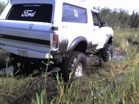 1995 Ford Bronco - White 1995 Ford Bronco is stuck in the mud off-road.